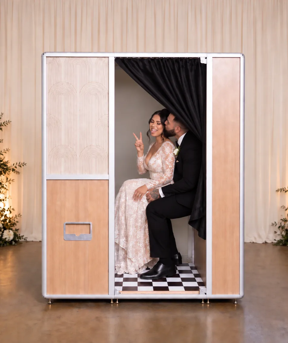 bride and groom inside enclosed photo booth at Colorado Springs wedding with Martini Moment