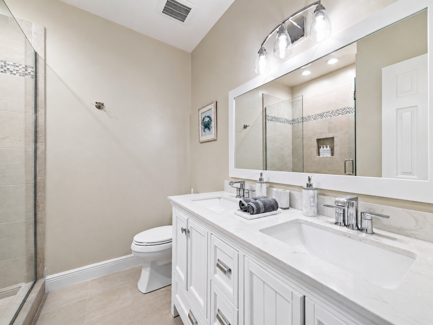 Bright bathroom with double sink and vanity mirror at Sand Crab Hideaway