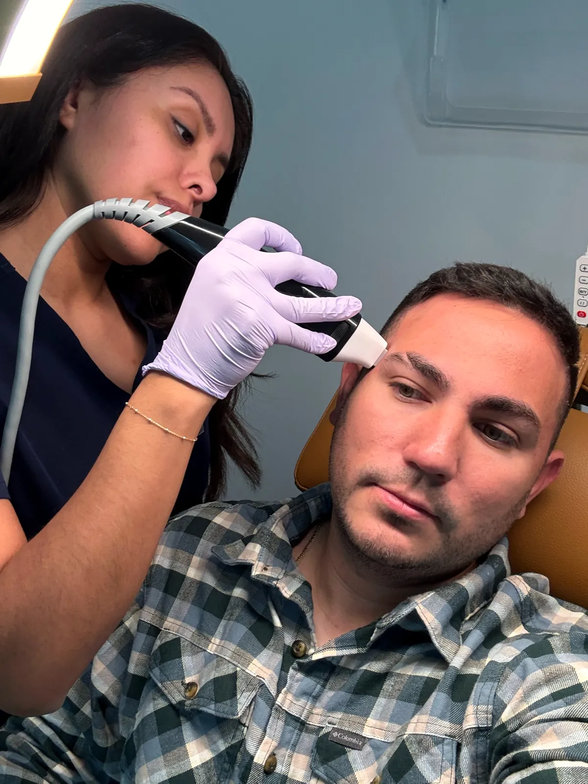 Jennifer Velazquez, RN, performing a skin treatment on a male client at JENNVIE in Westport, CT