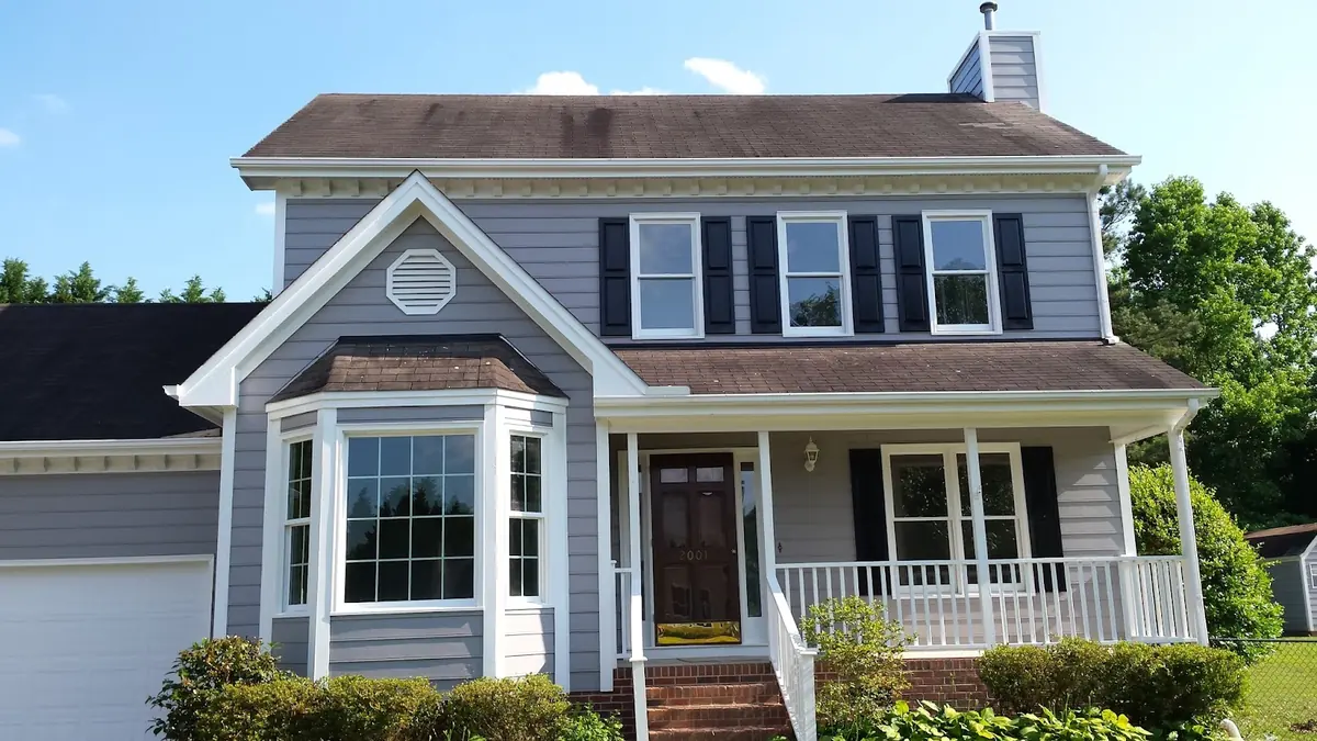 Two-story blue-gray home with white trim and black shutters