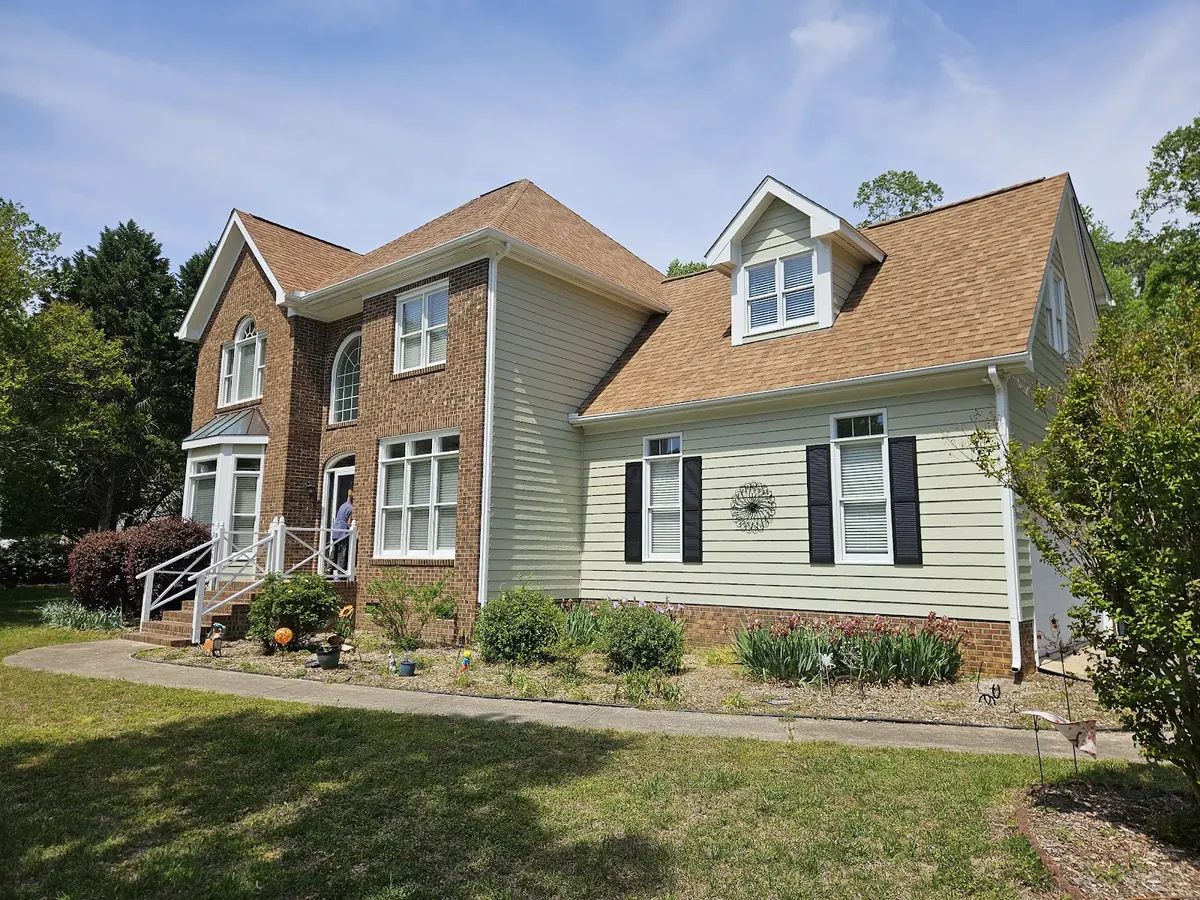 Two-story home with fresh sage green siding, white trim and black shutters