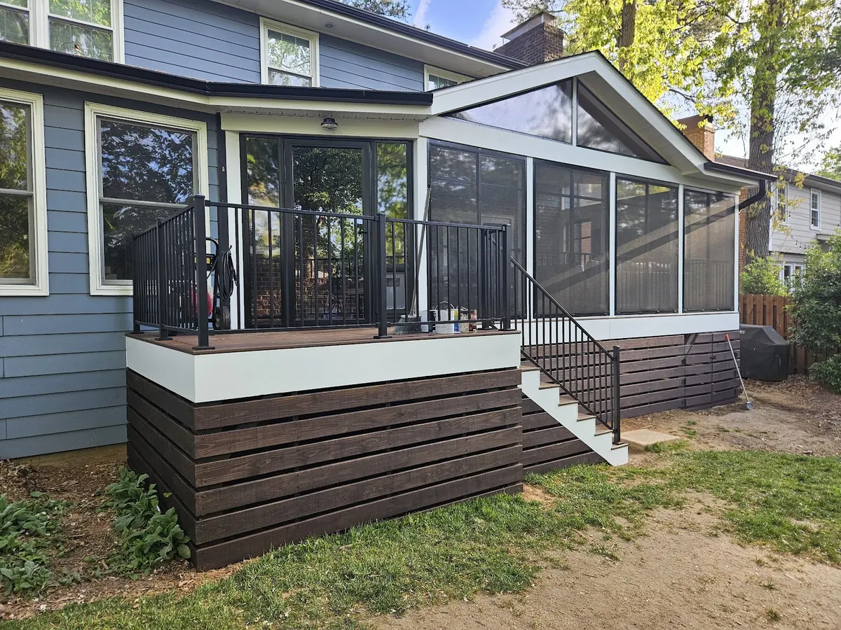 Blue-gray home with screened porch, black railings and white stairs