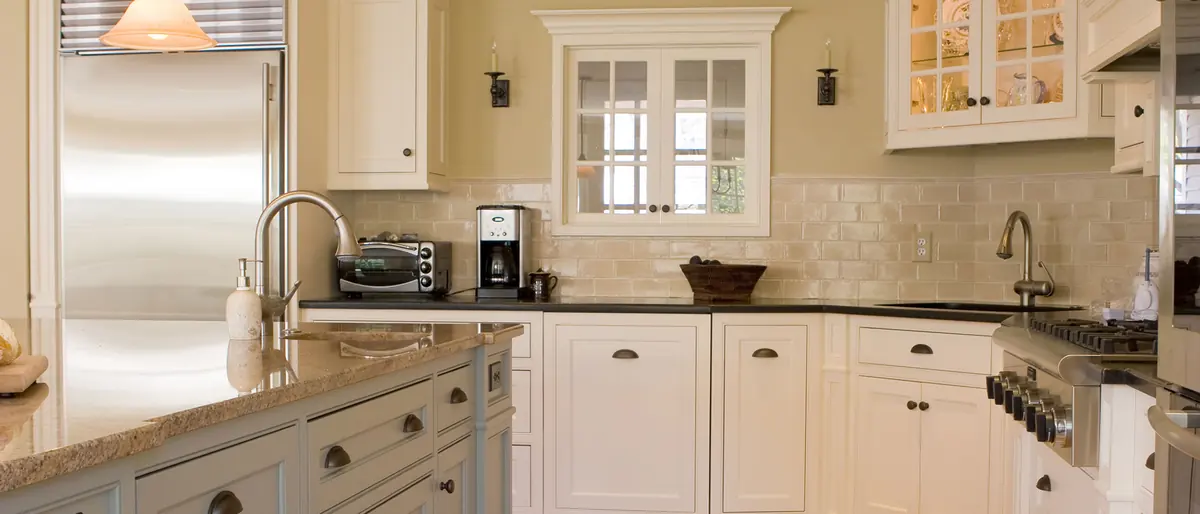 Finished kitchen with white cabinetry, granite countertops and stainless appliances