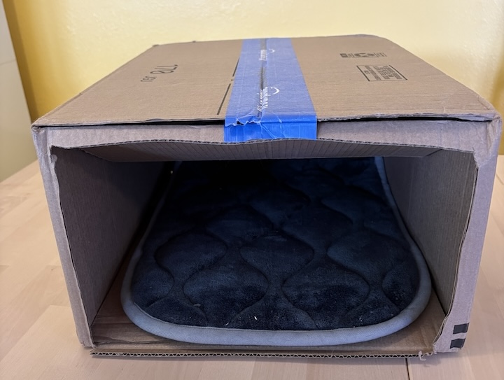 A medium-sized box prepped with a cat mat and ready to be covered by a t-shirt. A medium-sized box prepped with a cat mat and ready to be covered by a t-shirt.