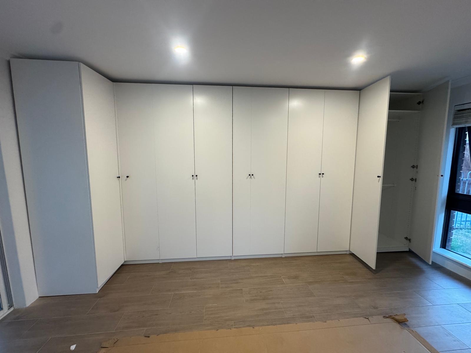 Large white wardrobe installation across wall in Perth
