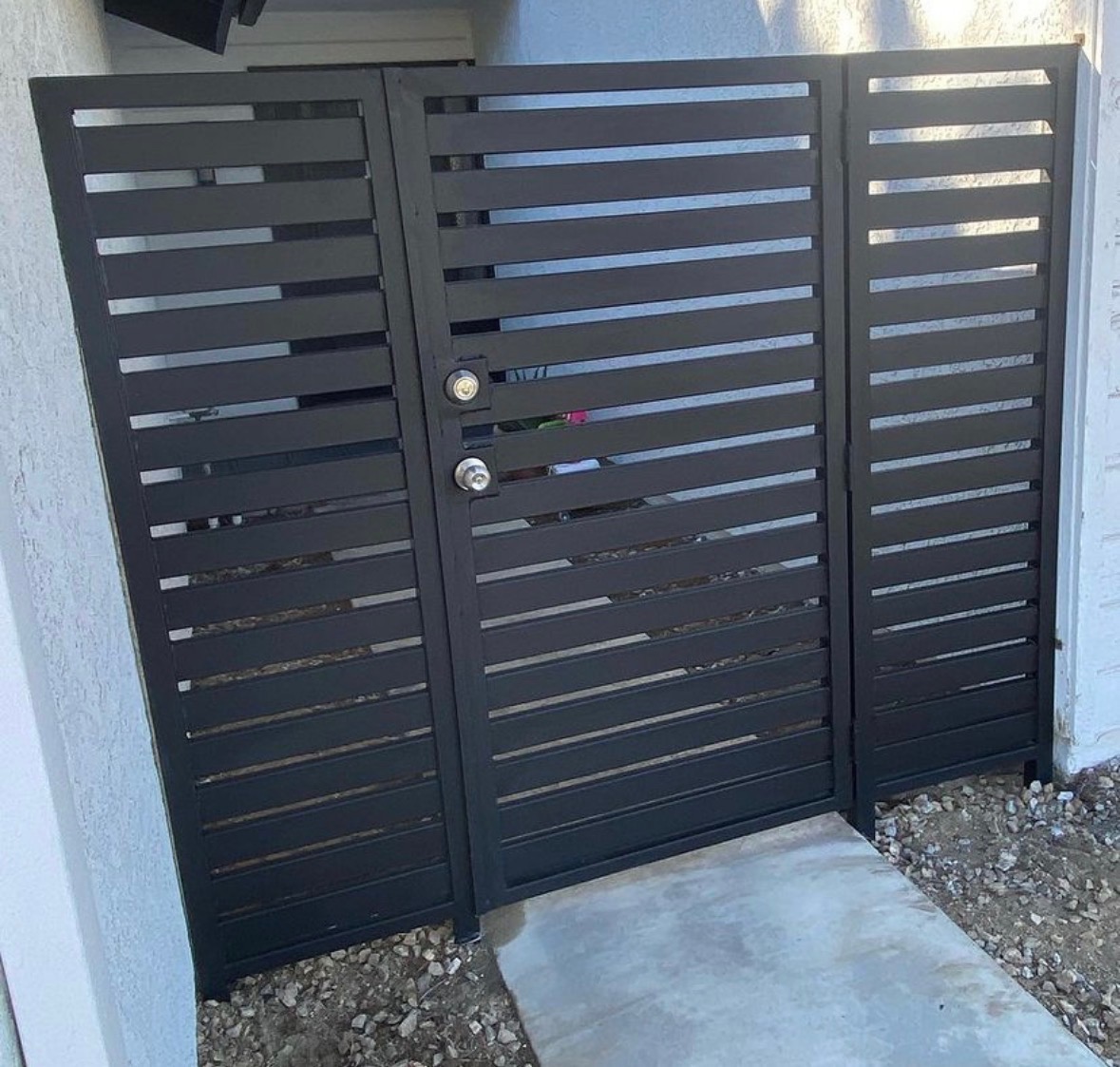 Modern black horizontal iron fence and gate panel set at a Santa Ana residence