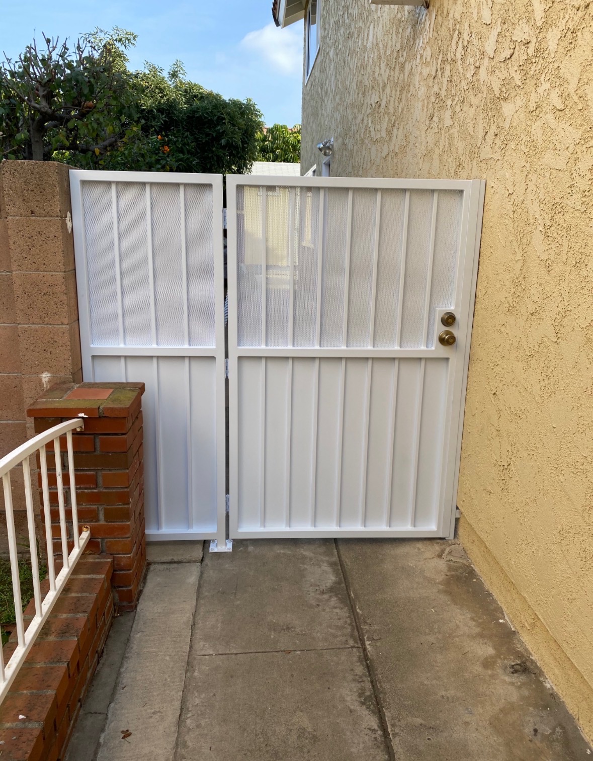 White iron double privacy gate at a pedestrian side yard entrance
