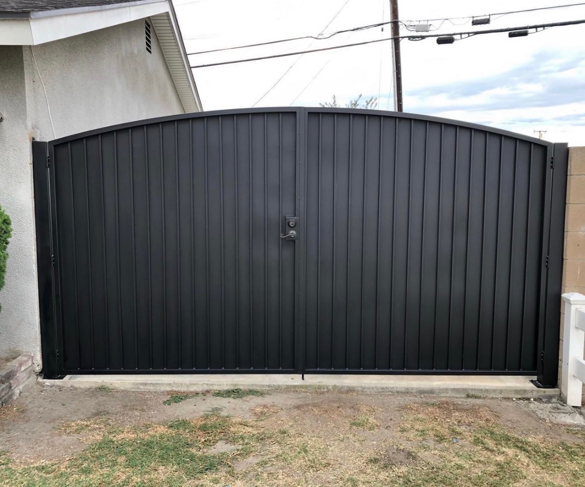 Large black steel arched dual-swing driveway gate in Long Beach