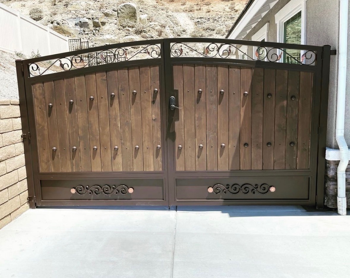 Custom wood and iron arched driveway gate with scrollwork, Inland Empire installation