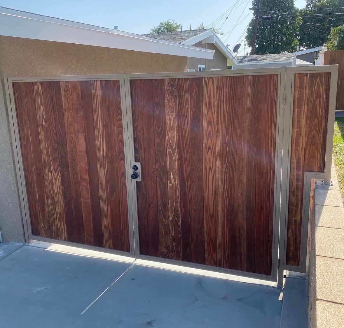 Steel-frame double driveway gate with vertical champagne cedar panels
