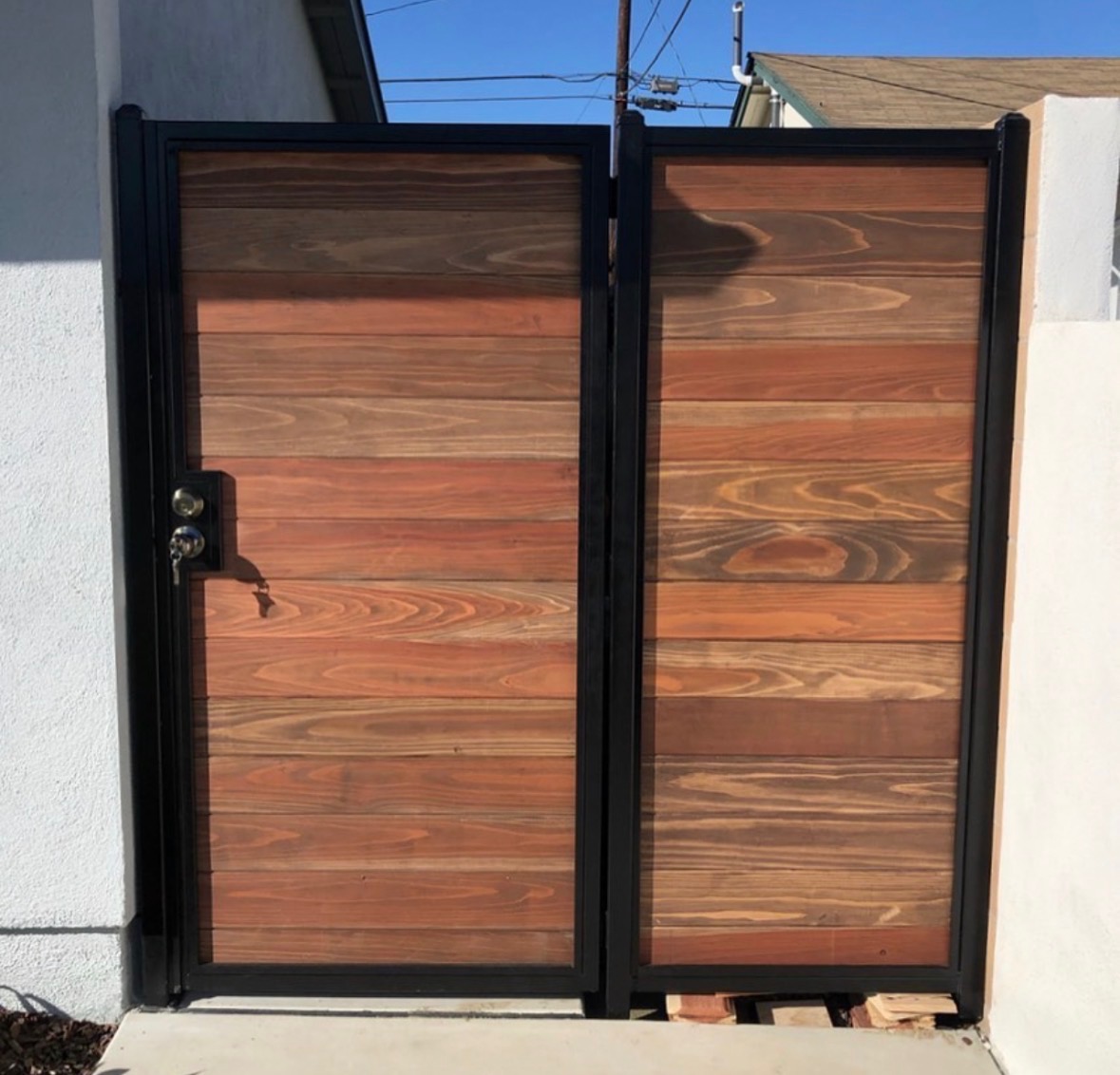 Steel-frame double gate with horizontal cedar panels and a black frame