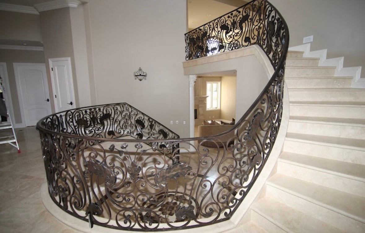 Grand curved wrought iron balcony railing with decorative ironwork