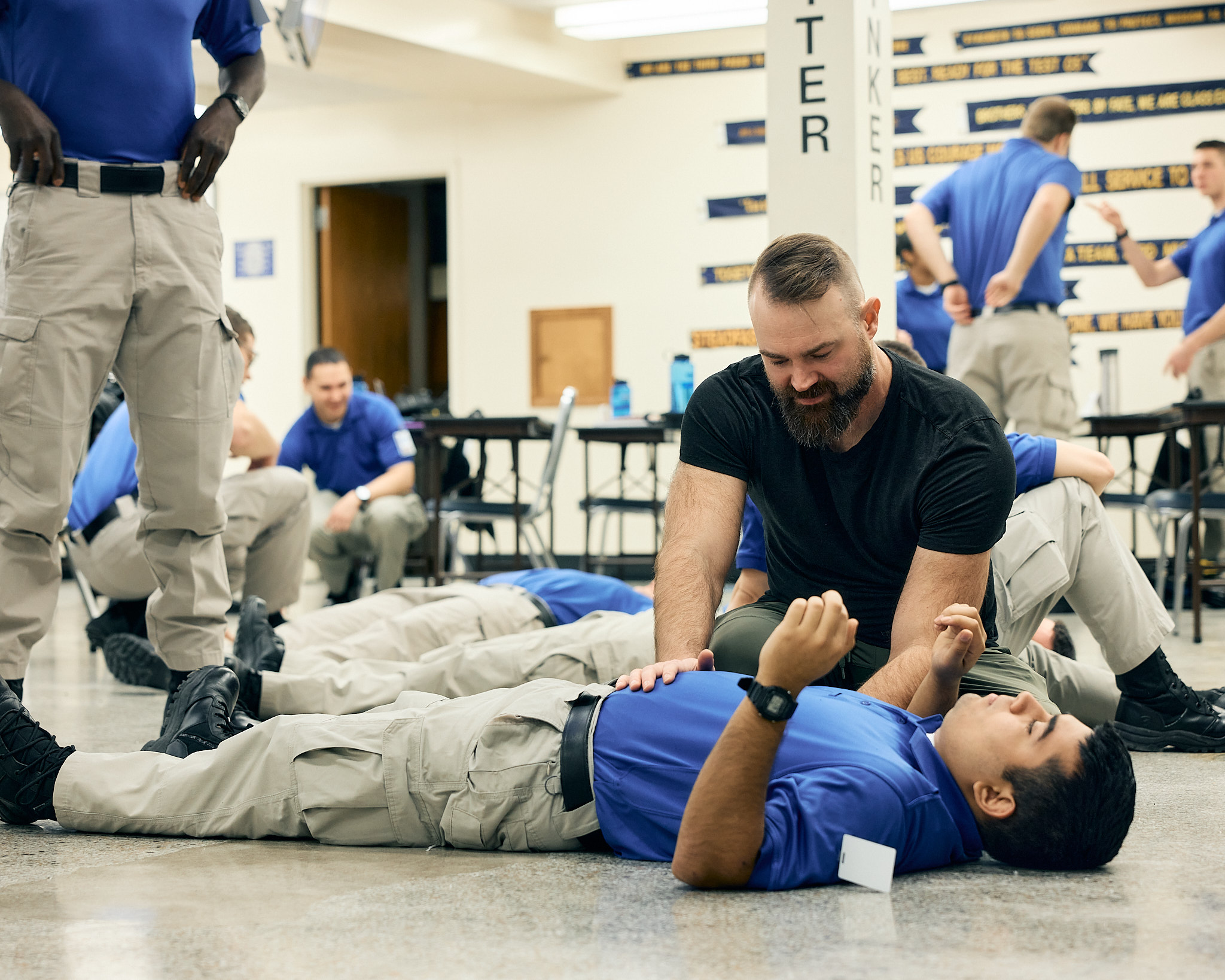 Police cadets practicing structured breath training on the academy floor
