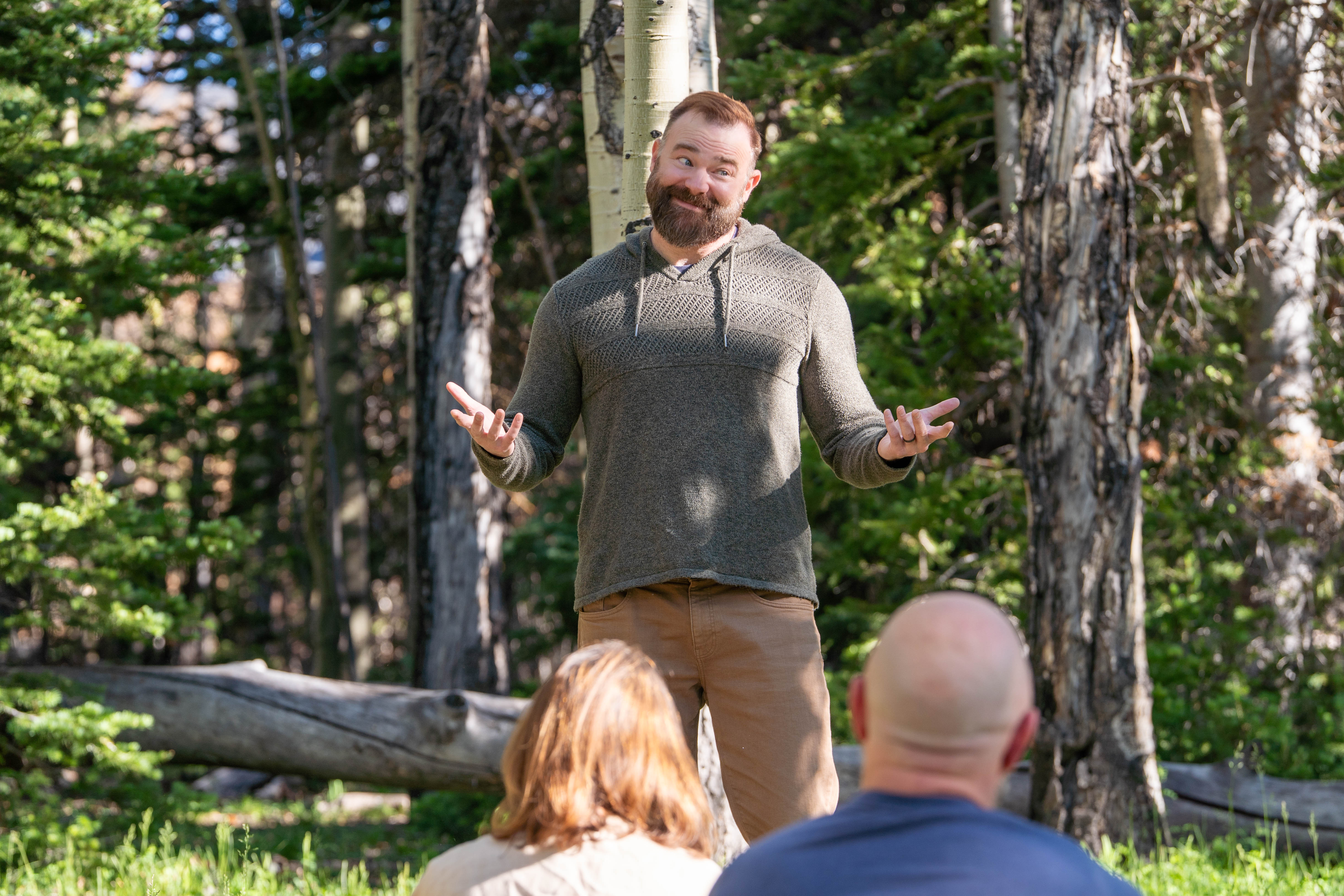 Jesse Coomer teaching outdoors to a seated group at the capstone