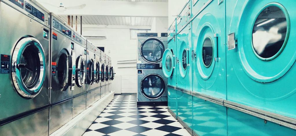 Row of teal commercial dryers at The Laundry Room
