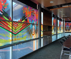 Vibrant full-color art prints on glass panels in corporate conference space