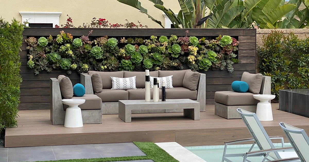 Succulent living wall behind outdoor lounge seating at a resort-style pool
