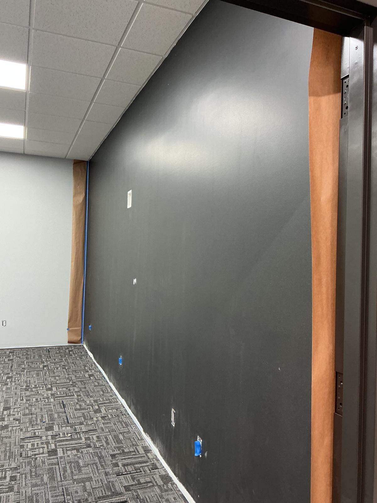 Charcoal accent wall with clean painter’s tape lines in an office