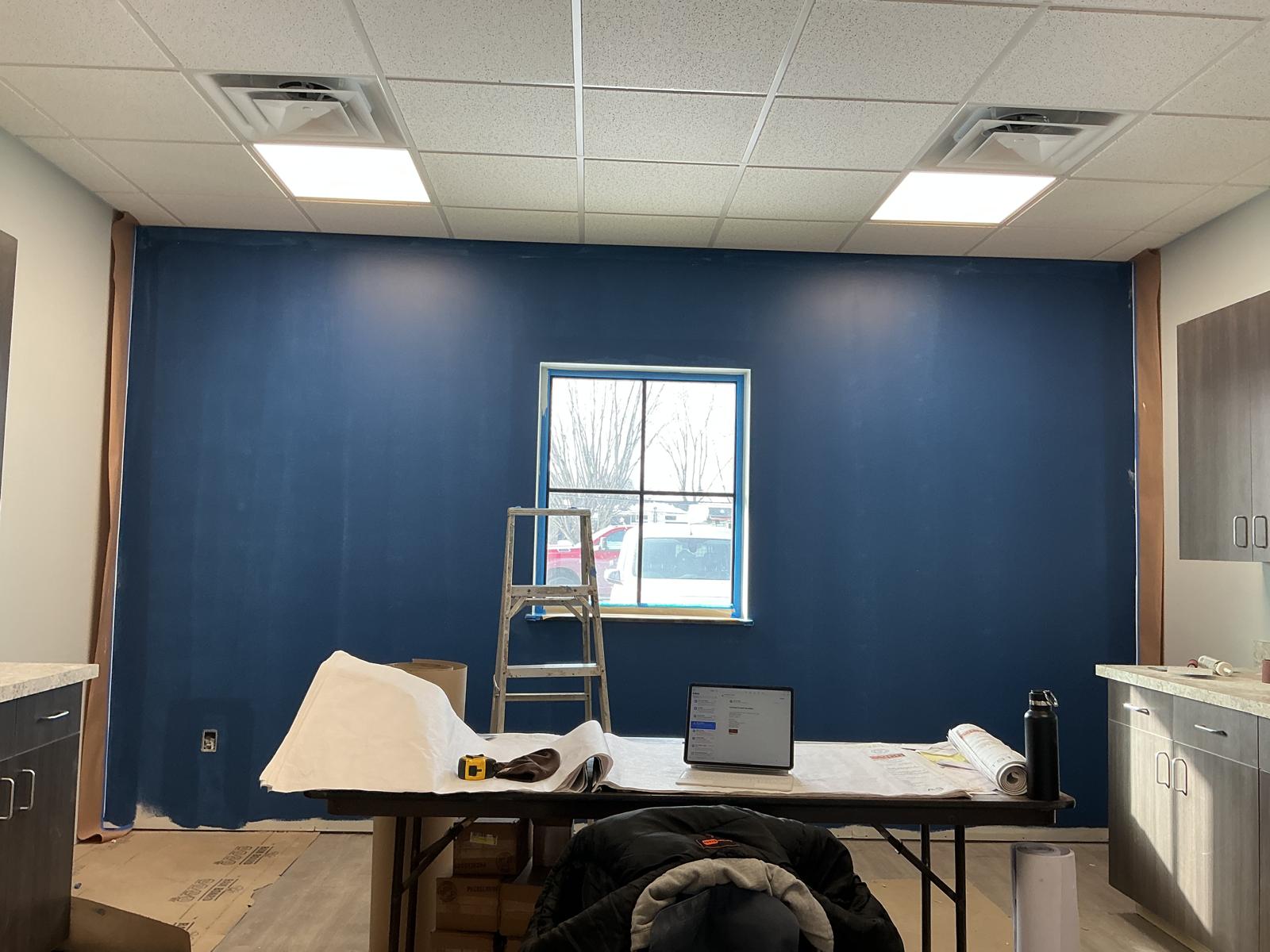 Deep blue accent wall around a window in a commercial break room