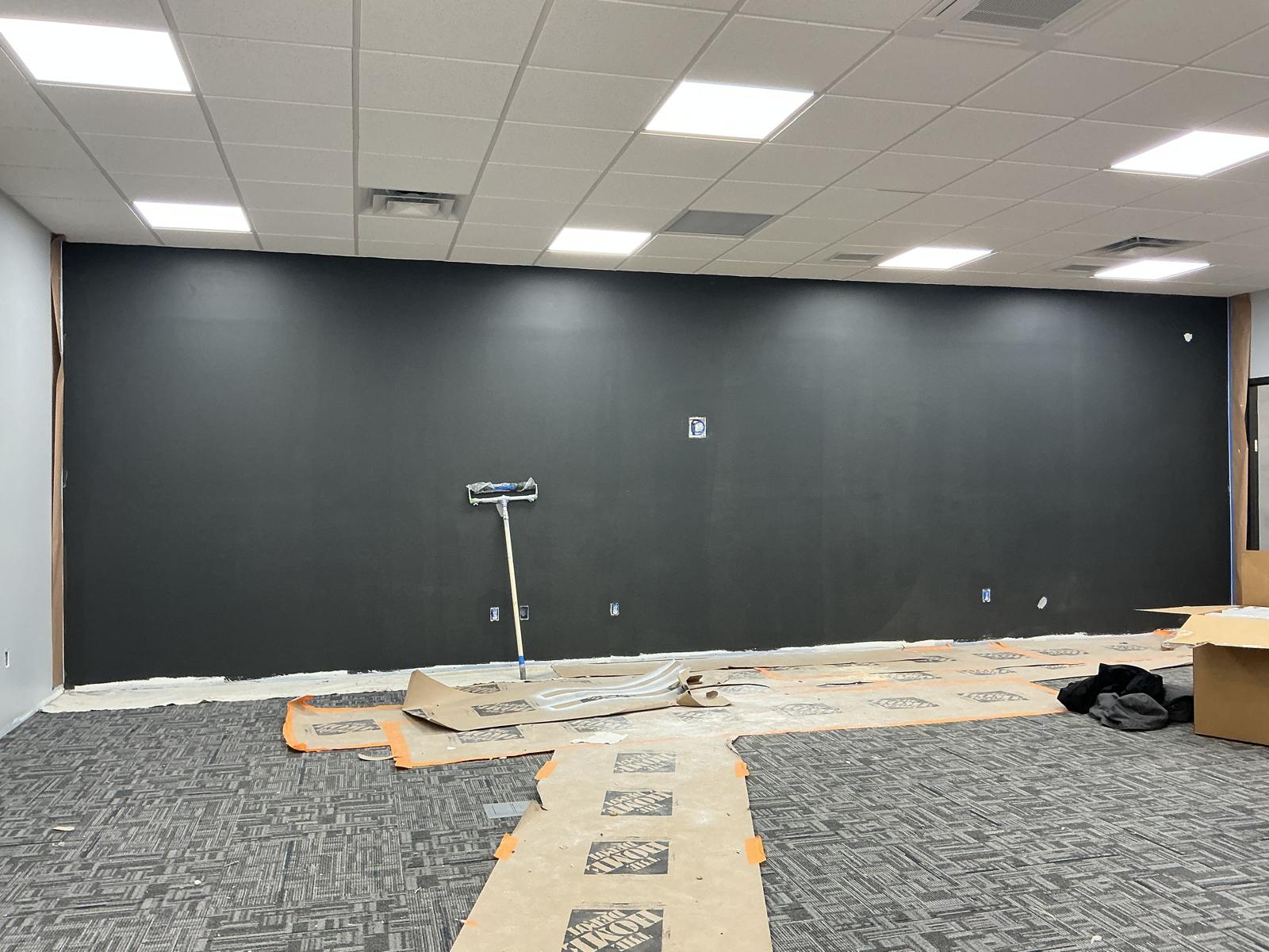 Freshly painted dark charcoal accent wall in a commercial office