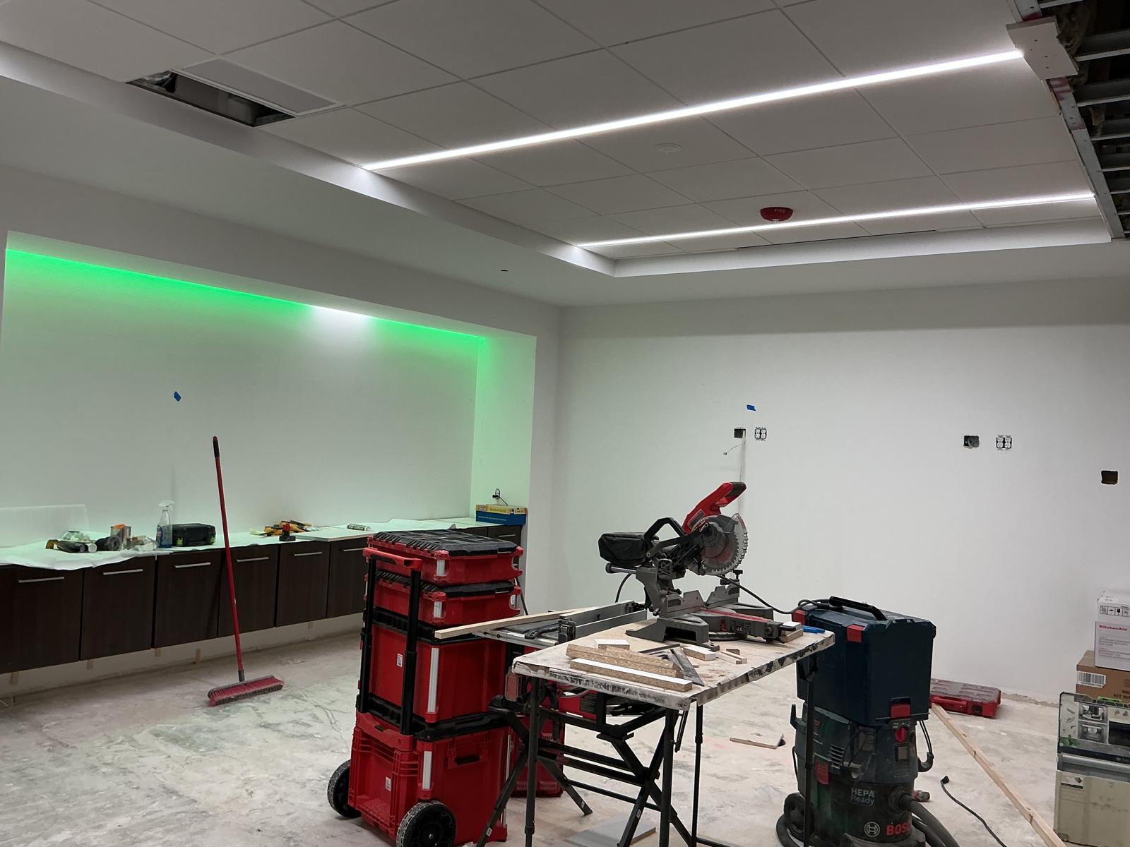 White painted room with green LED accent lighting and cabinets