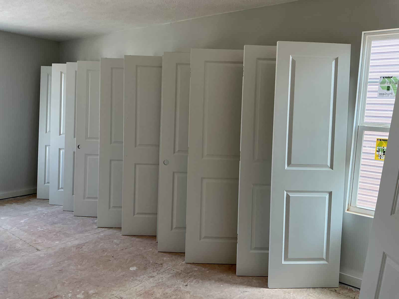 Row of white interior doors painted and ready for installation