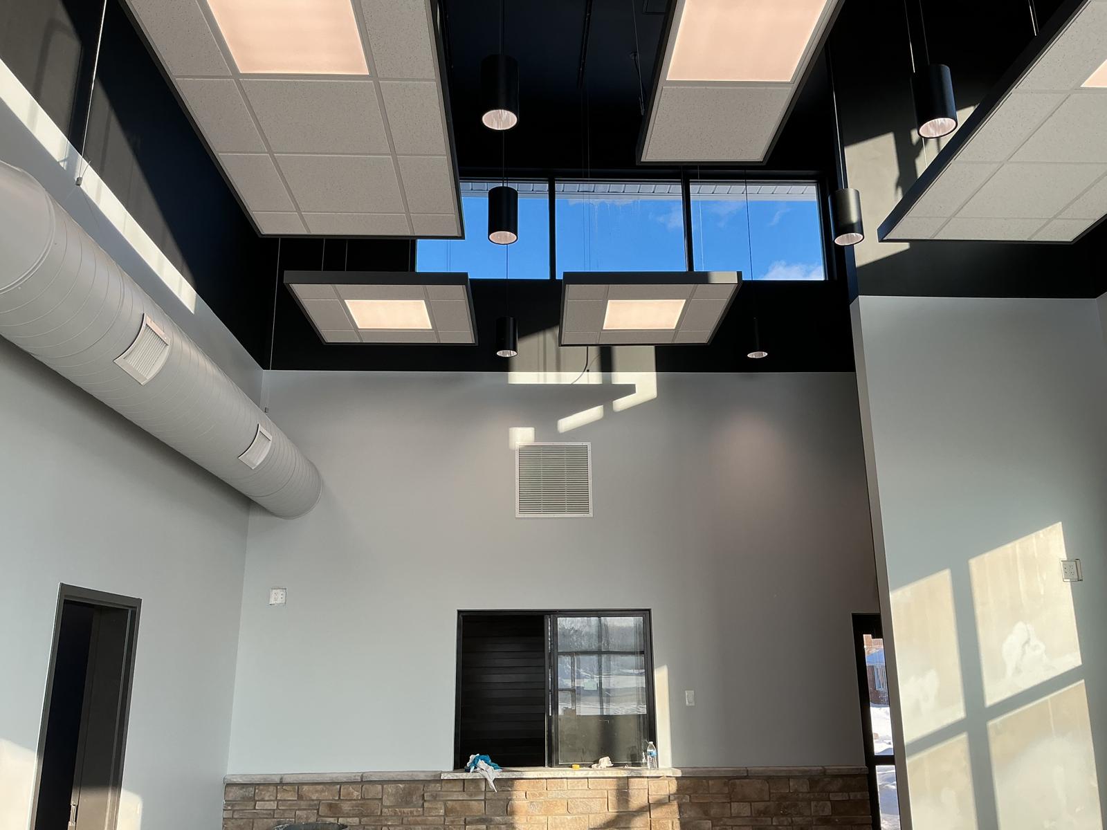 Tall commercial lobby with light gray walls and black upper walls