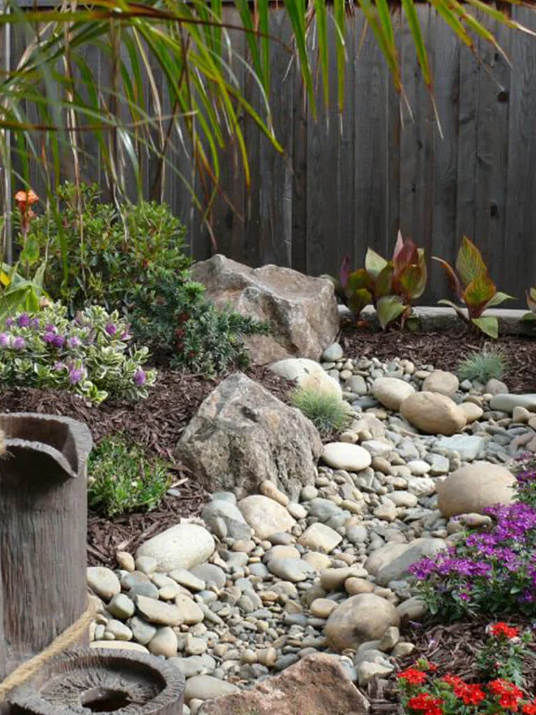 Water-wise dry creek, boulder accents, and xeriscape planting by Lavish Gardens Landscape