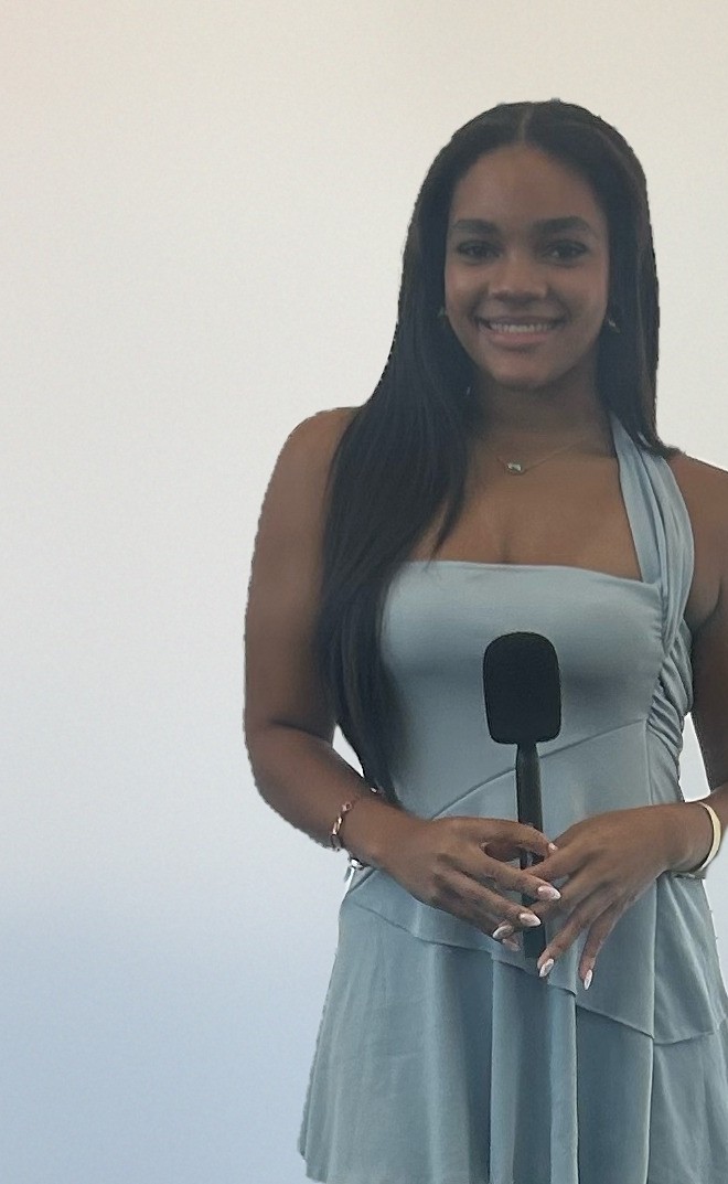 Chandler Mason smiling and holding a microphone, ready to go on air.