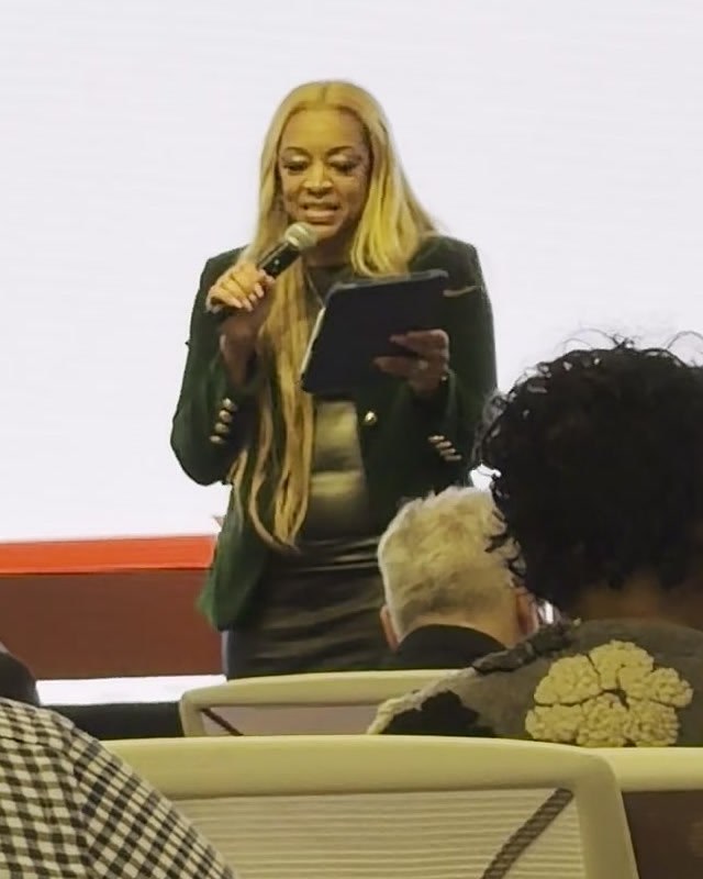 Shena Dixon Mason speaking to an audience with a microphone