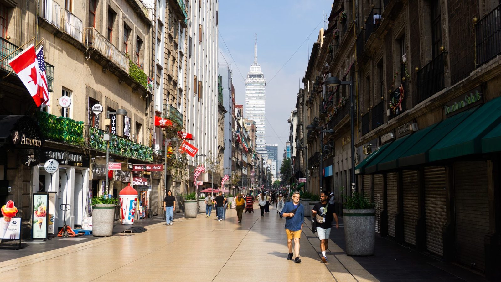 People walking down Madero street in Mexico City's historic center toward the Torre Latinoamericana