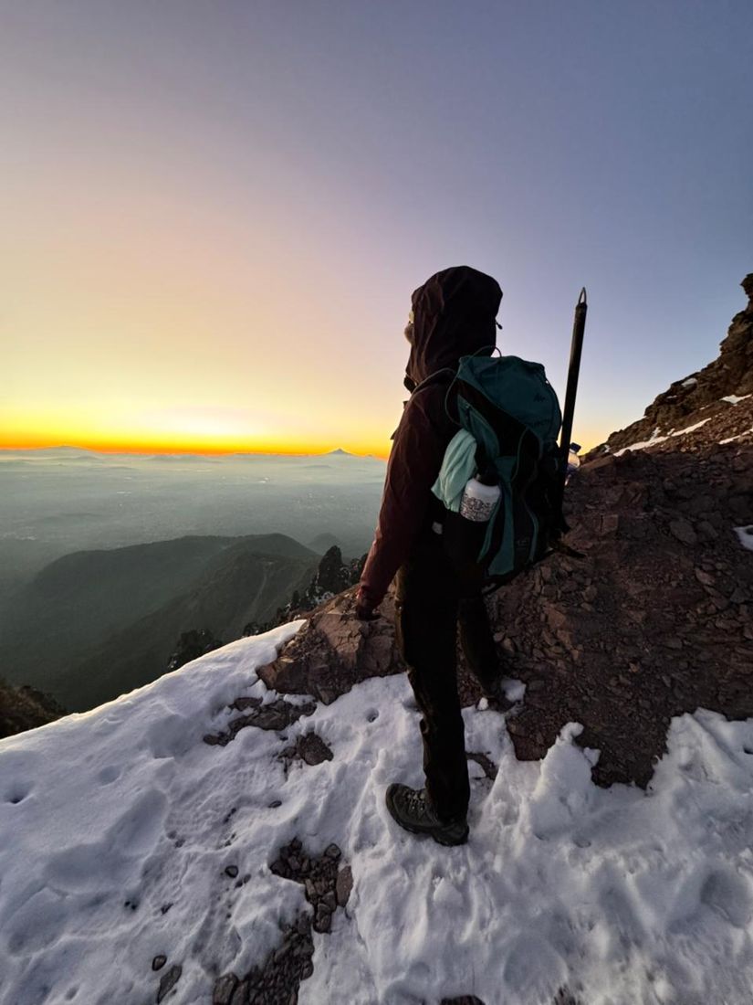 A climber at sunrise on the snowy upper slopes of La Malinche