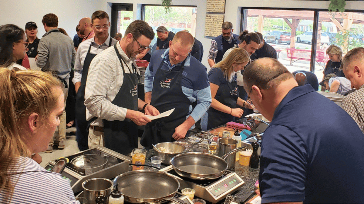 Private cooking event guests cooking together at The Learning Kitchen in Cincinnati Private cooking event guests cooking together at The Learning Kitchen in Cincinnati
