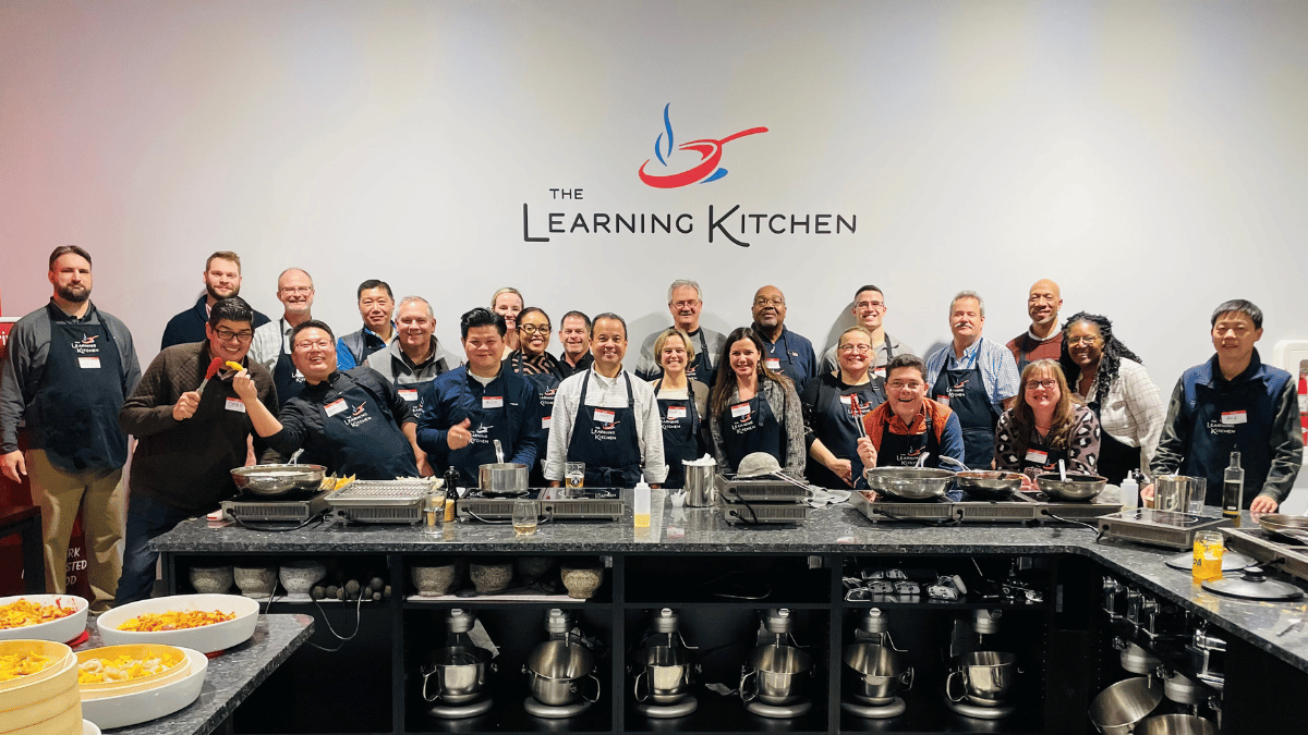 Private cooking event guests cooking together at The Learning Kitchen in Cincinnati Private cooking event guests cooking together at The Learning Kitchen in Cincinnati