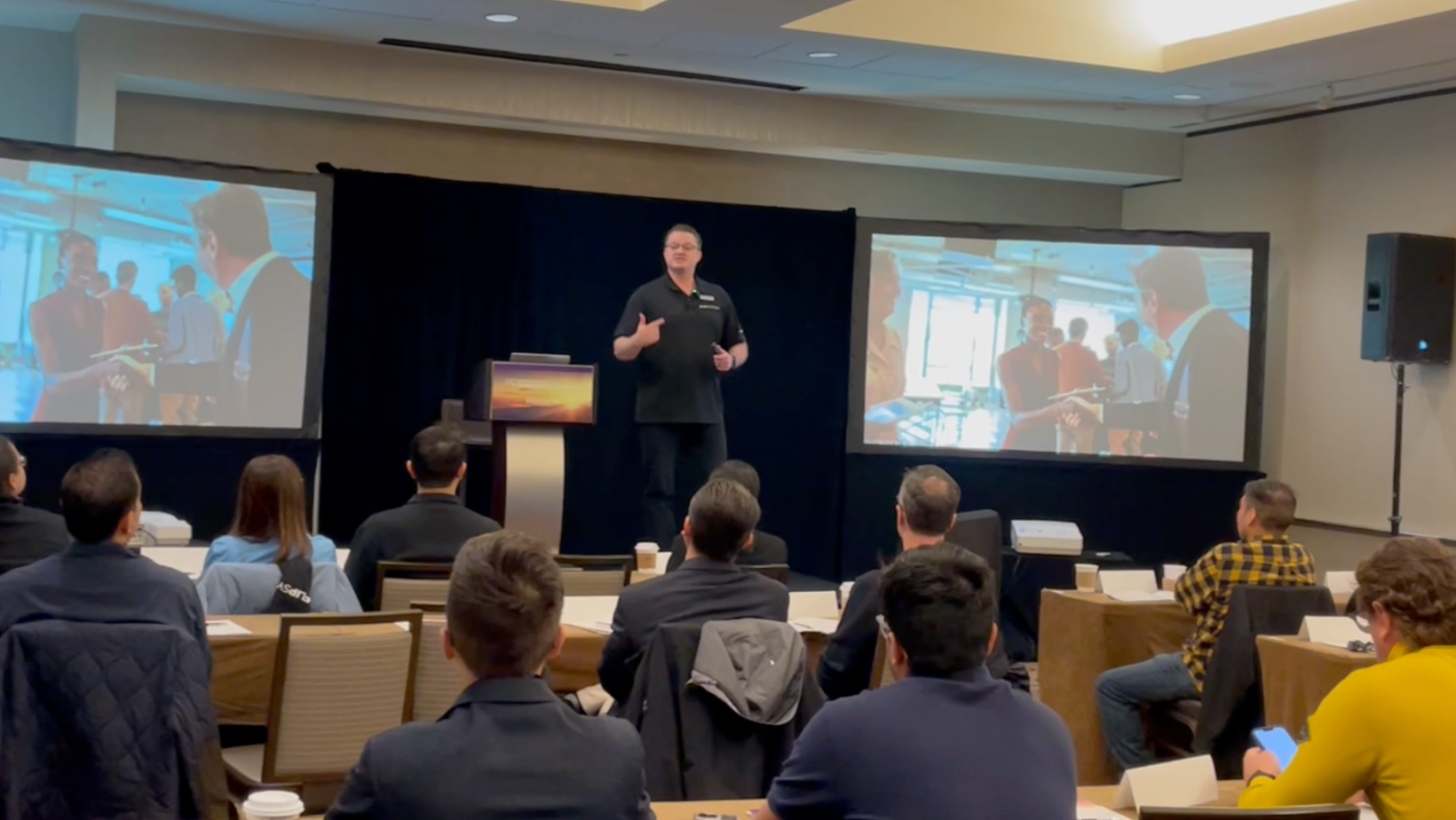 Boyd Hoffmann speaking on stage at a live event