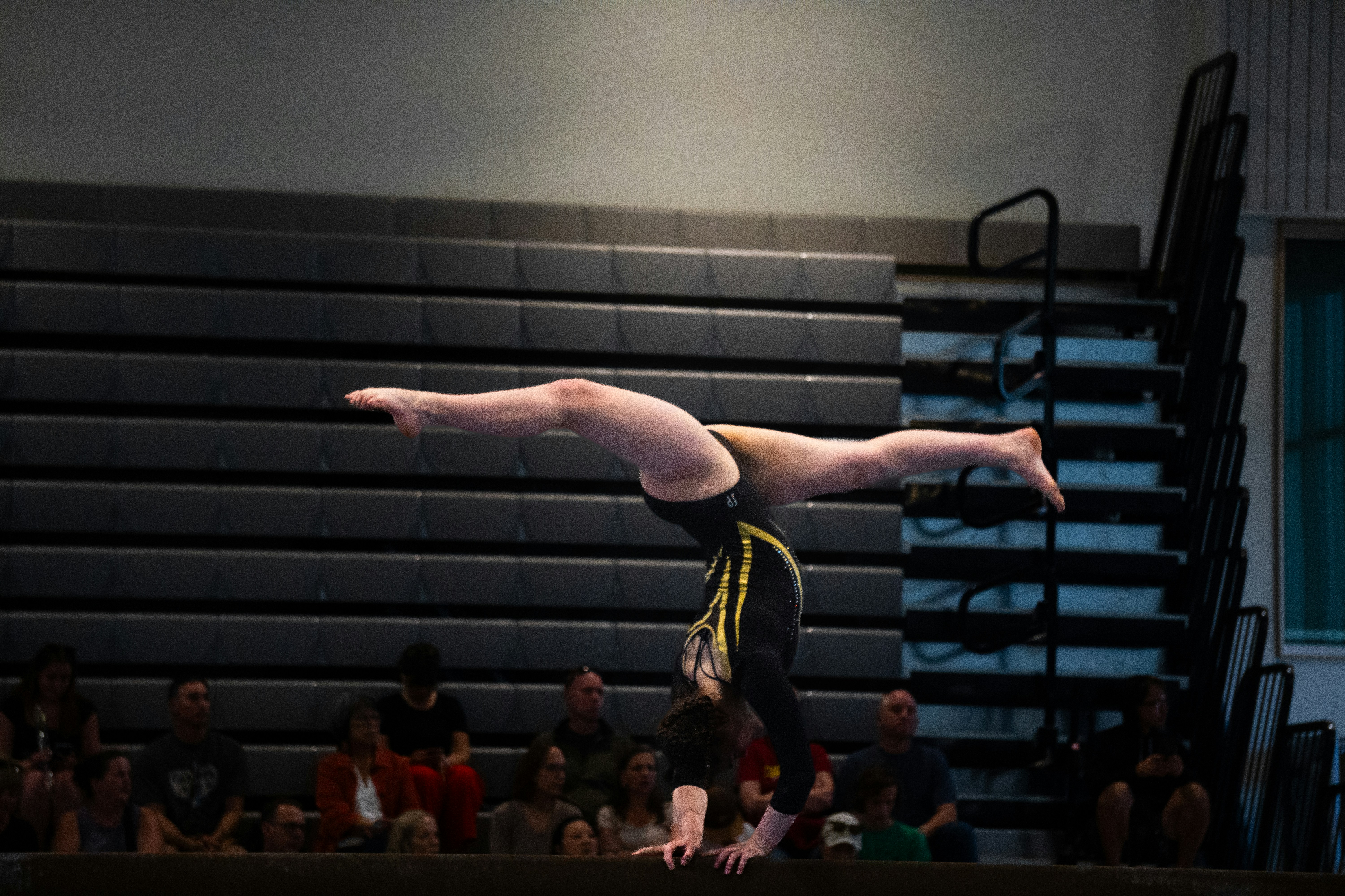 female gymnast doing a handstand on a balance beam