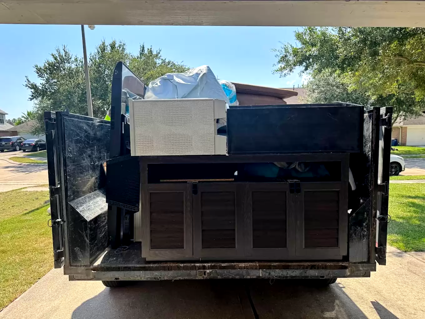 Dump trailer loaded with furniture and an appliance