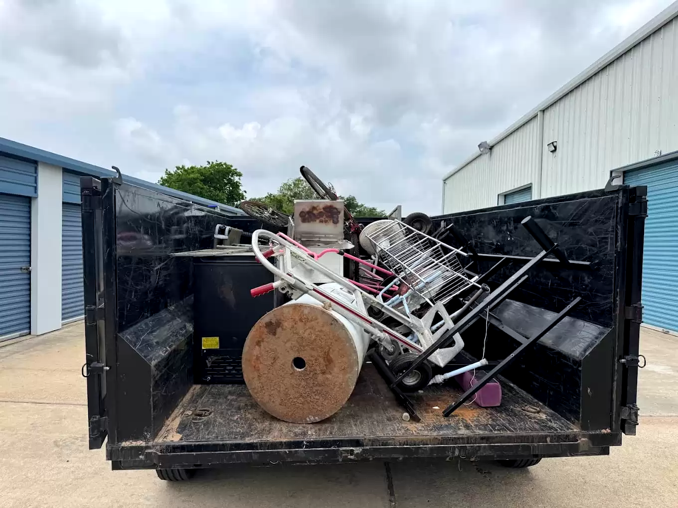 Metal furniture and equipment loaded in a dump trailer