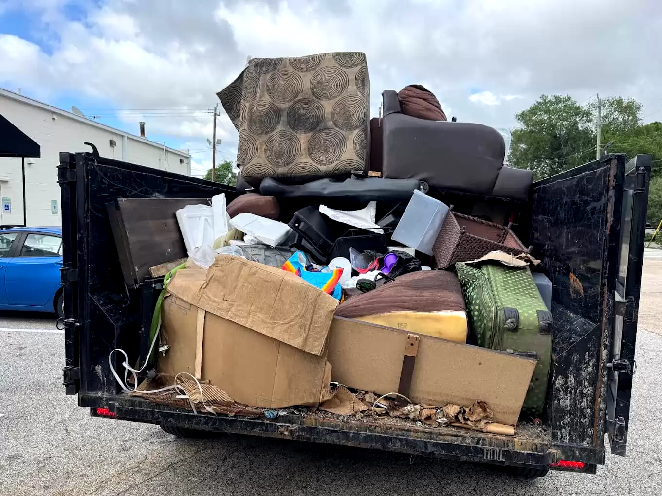 Furniture, boxes and household junk loaded in a dump trailer
