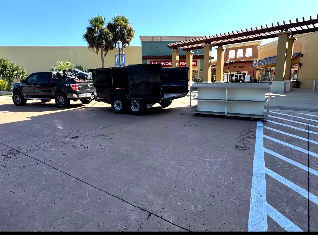 Pickup and dump trailer outside a retail property