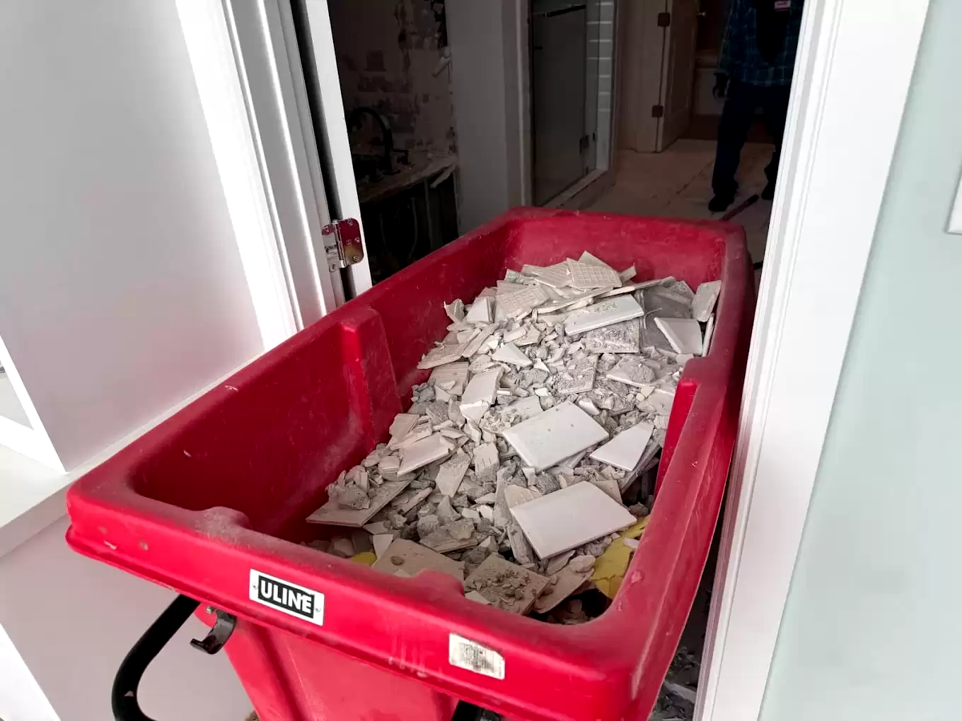Broken drywall in a red debris cart