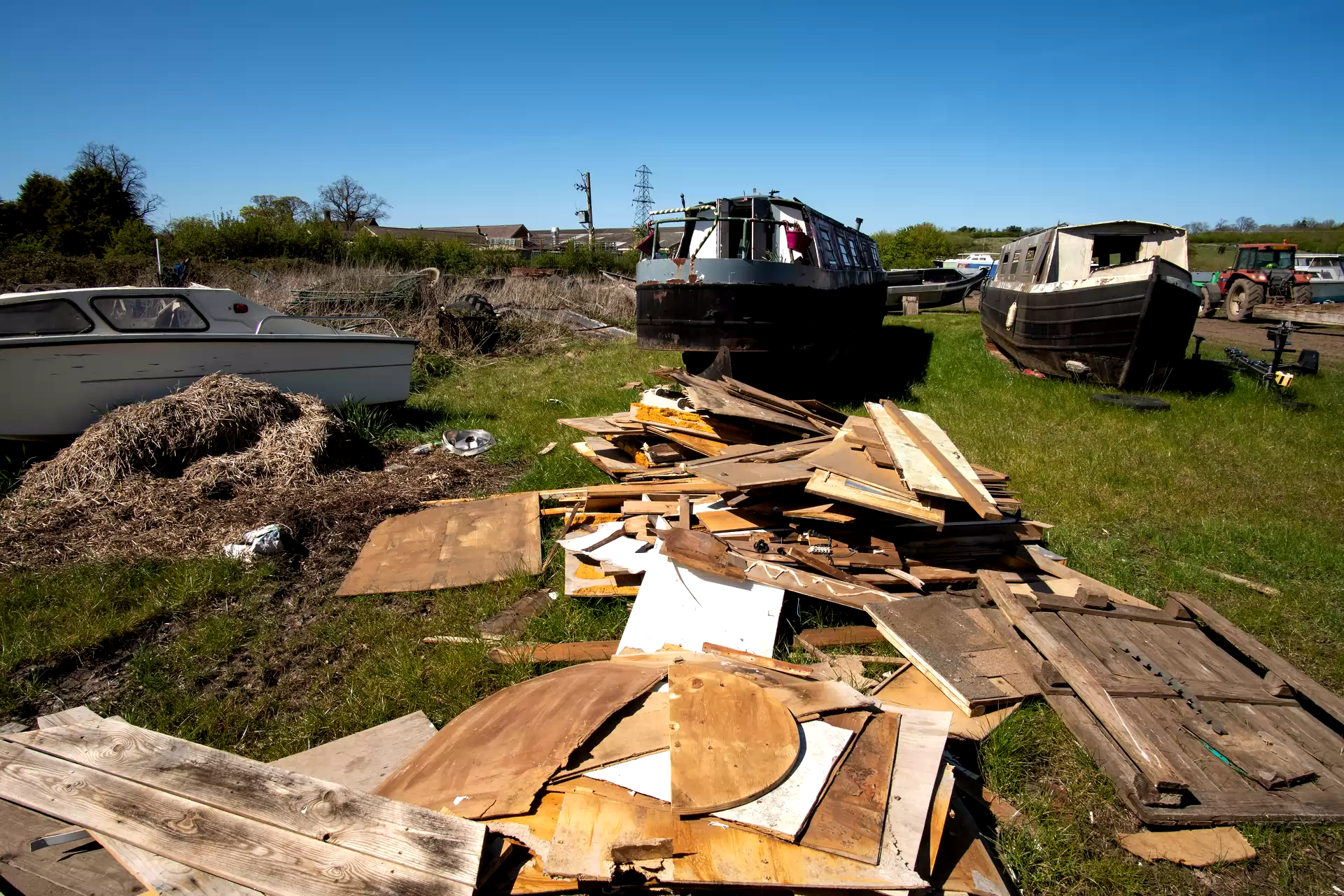 Boats and dismantled wood panels in an outdoor storage area
