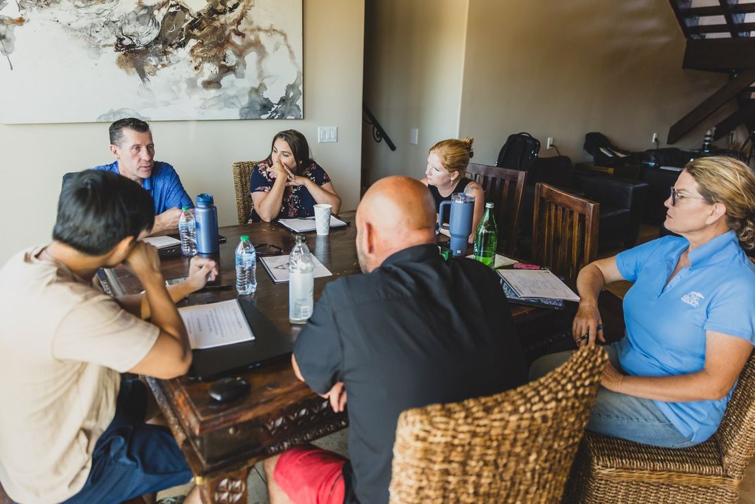 Mastermind members working through a problem around a dining table