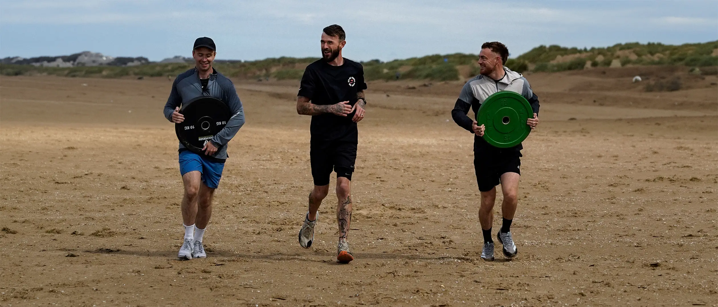 Jamie running plate carries with clients on the beach