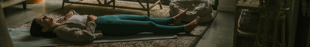Woman lying in Savasana with hands on her belly and chest