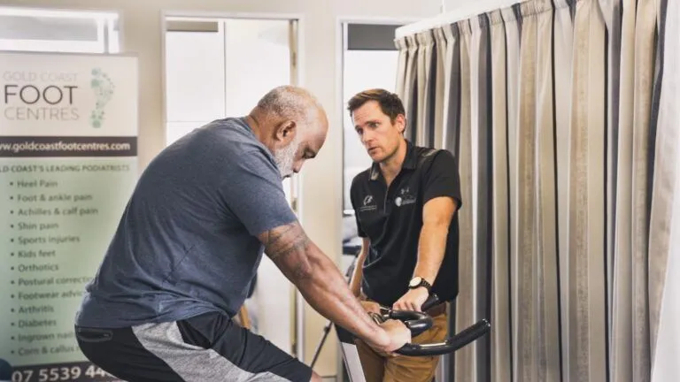 Dr. Adam Walker discussing knee education with a patient to improve understanding of knee OA at Gold Coast Knee Group