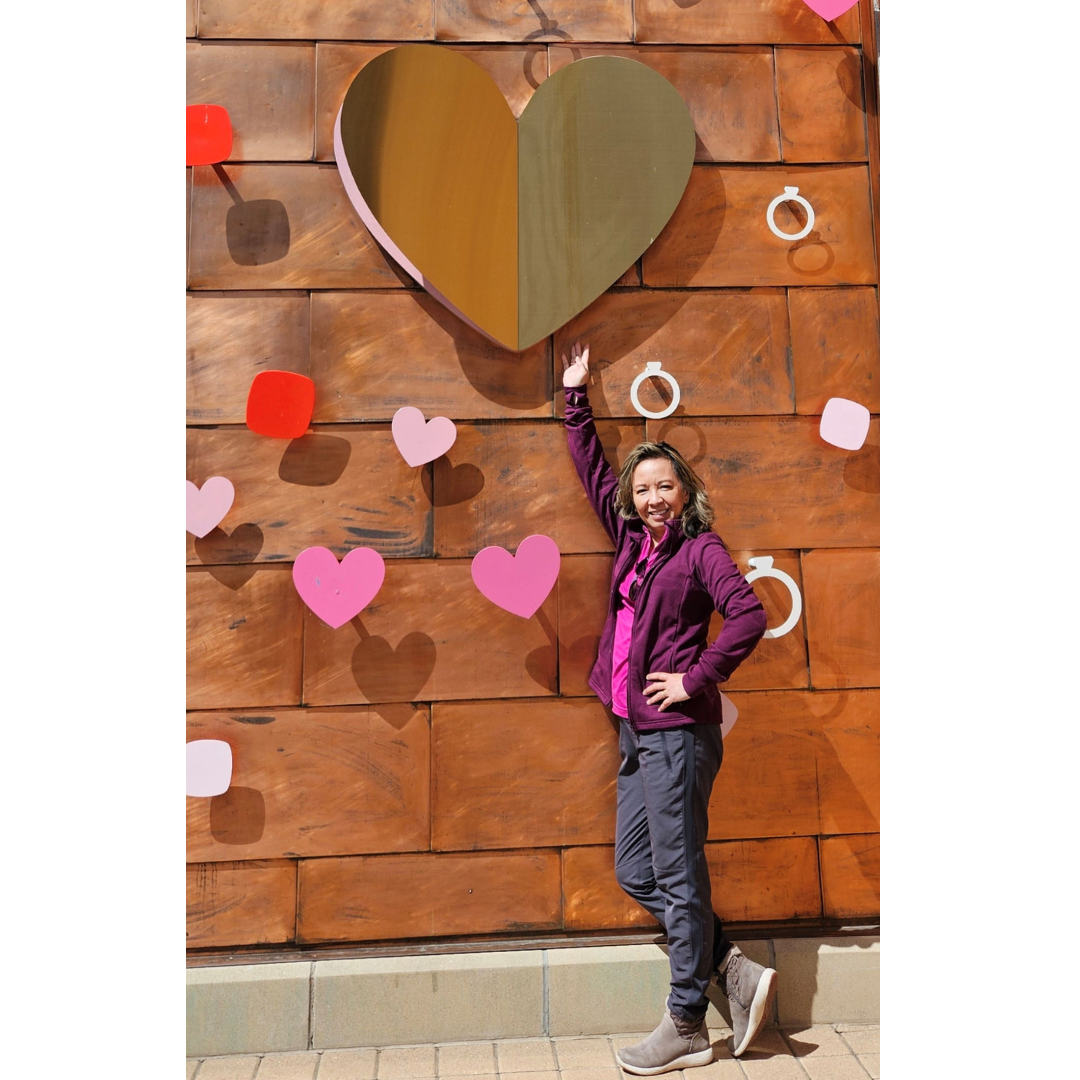 Annabelle Johnson standing in front of a large heart mural
