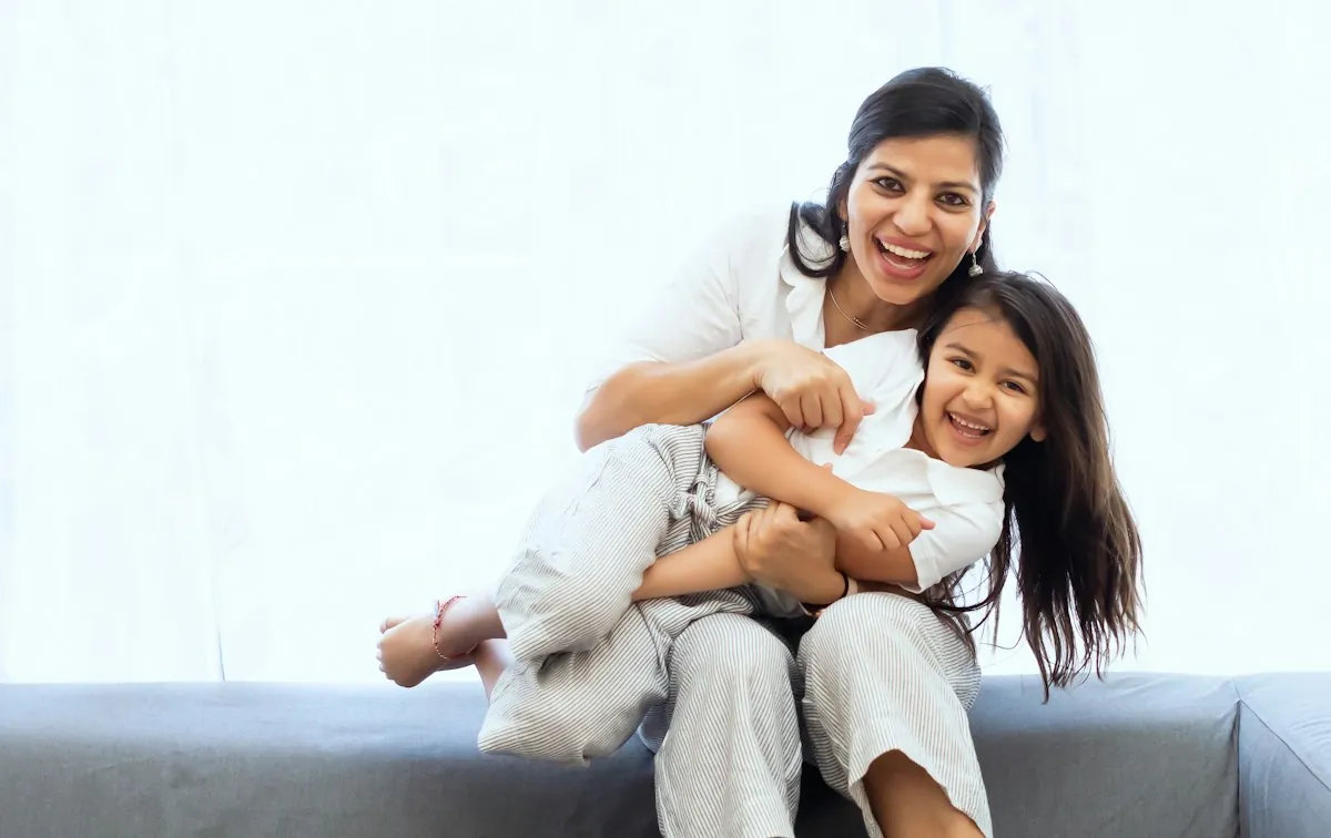 A mother and daughter laughing together at home