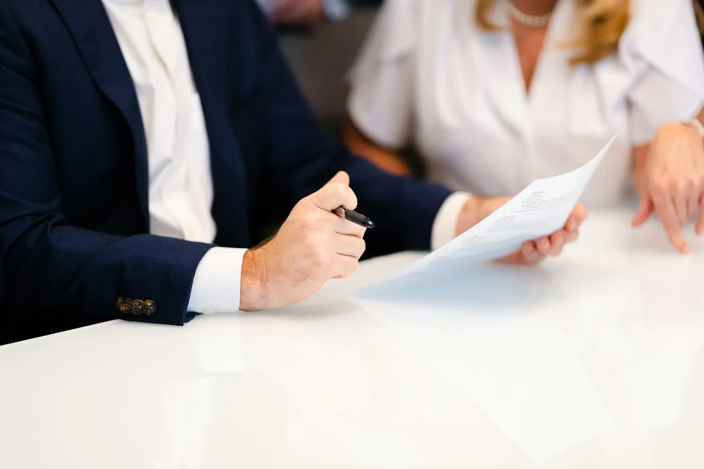 An attorney and a client going over a document at a white table