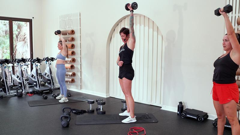 Members doing an overhead dumbbell press